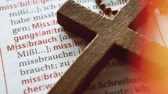Kreuz auf einem Wörterbuch mit dem Wort "Missbrauch"