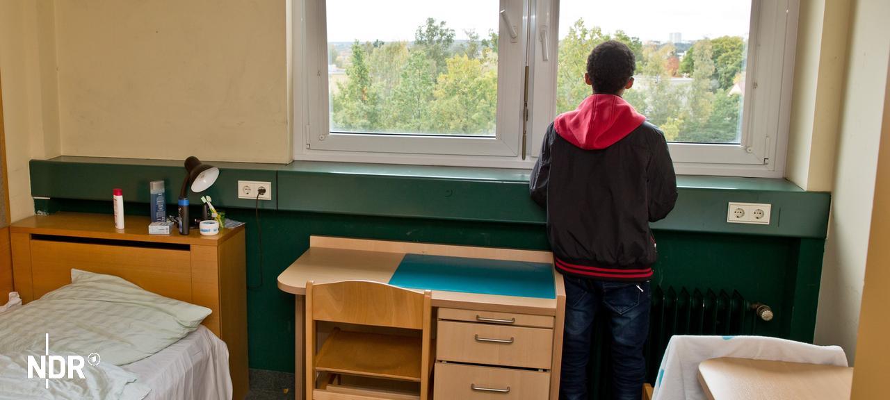 Ein Junge steht in einem Zimmer und schaut aus dem Fenster. | Daniel Karmann, dpa-picture alliance Ein Junge steht in einem Zimmer und schaut aus dem Fenster.