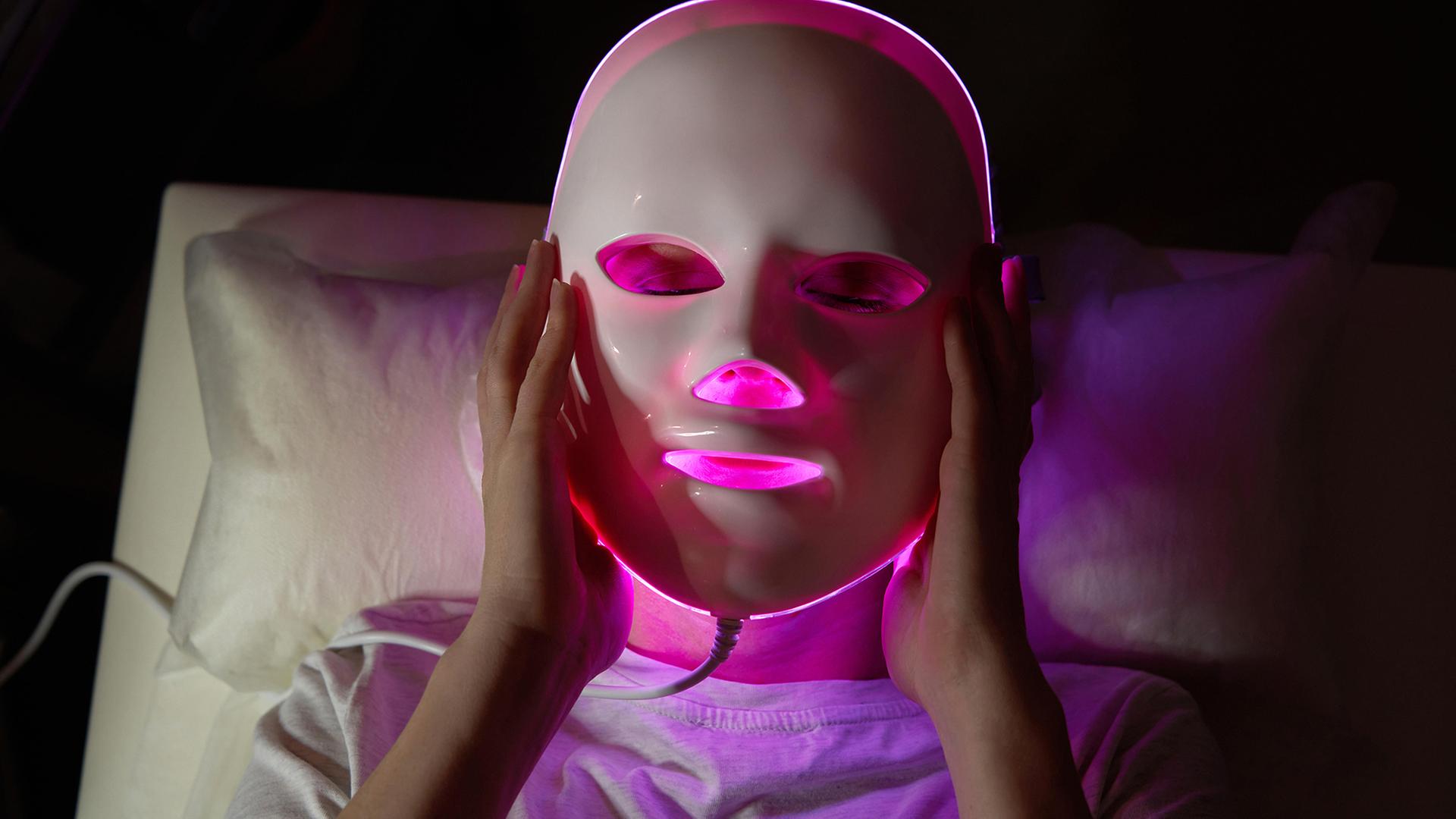 Eine Frau trägt eine LED Licht Therapie Maske. | picture alliance, Zoonar, Maria Kraynova