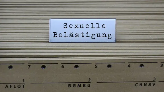 Auf dem Registerschild einer Karteikarte stehen in Schreibmaschinen-Schrift die Worte "Sexuelle Belästigung". (Themenbild)