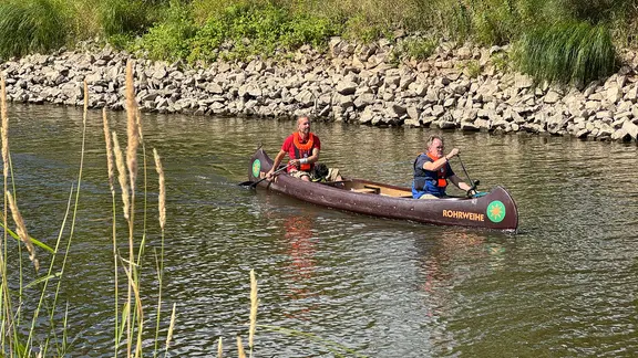 Zwei Personen fahren mit einem Kanu über die Elbe.