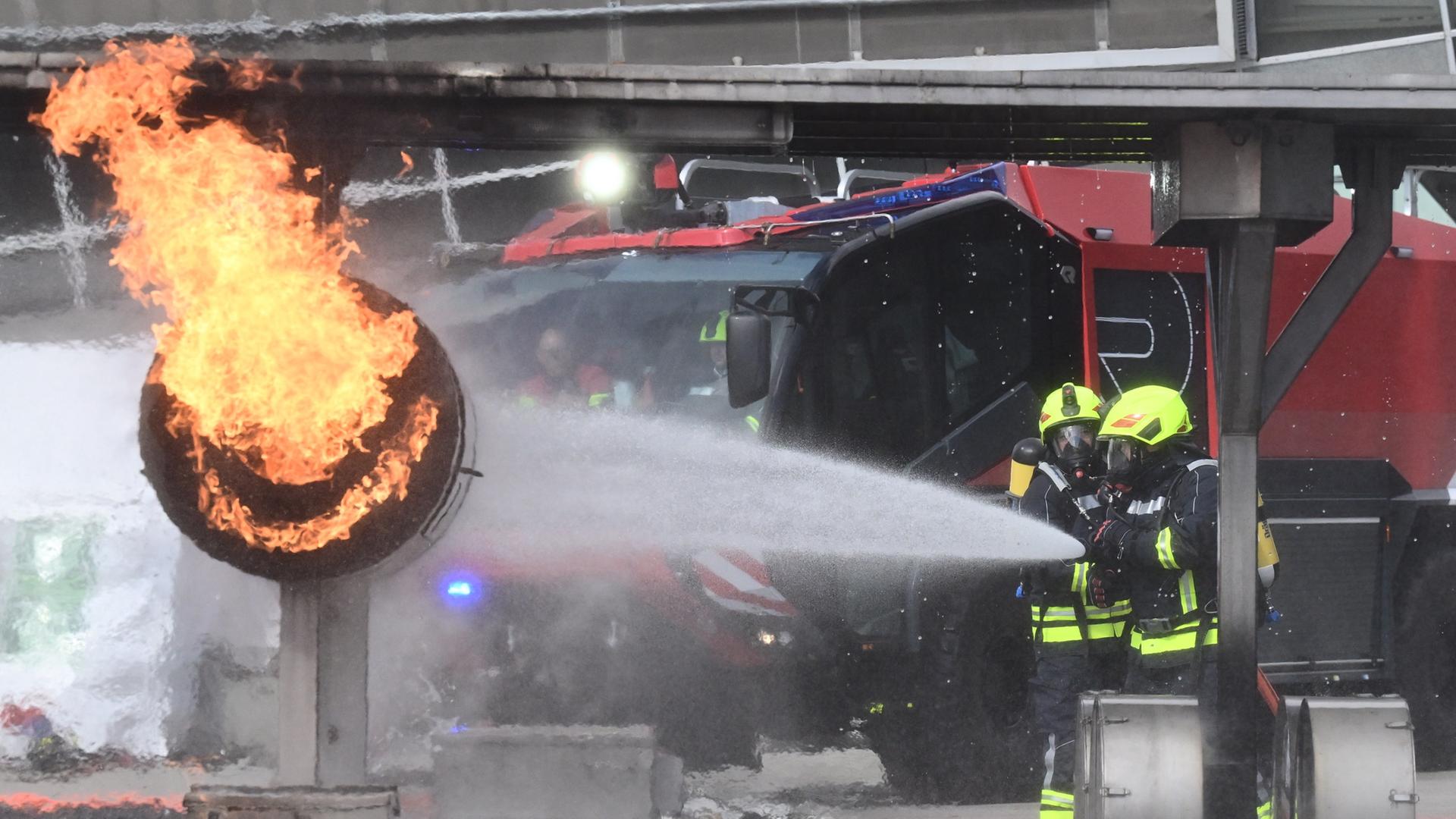 Feuerwehrkräfte löschen bei der Messe Interschutz einen simulierten Brand. | picture alliance/dpa, Julian Stratenschulte