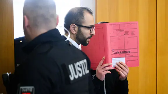 Der Angeklagte (r) kommt mit seinem Anwalt Roy Khalaf in den Gerichtssaal im Landgericht Hildesheim.