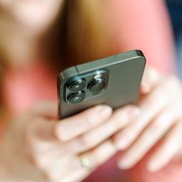 Eine Frau hält ein Smartphone in der Hand.