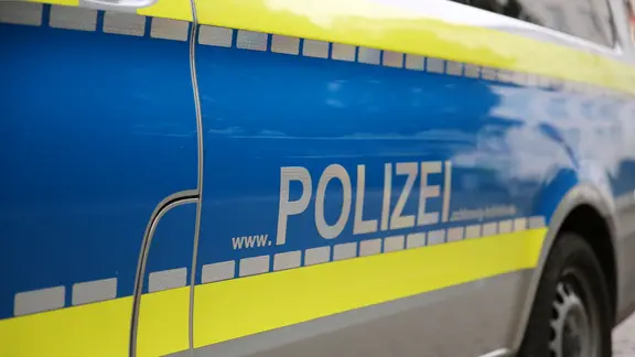 Schriftzug "www.POLIZEI.schleswig-holstein.de" steht an der Tür eines Streifenwagens der Polizei.