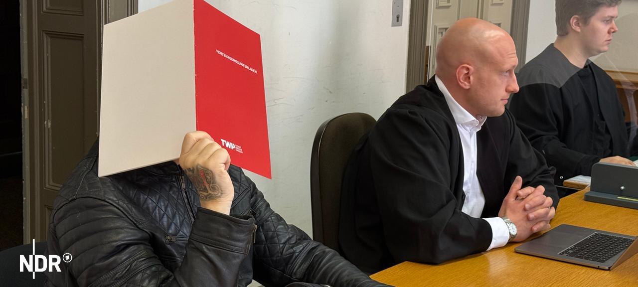 Ein wegen versuchter räuberischer Erpressung angeklagter Mann hält sich im Gericht in Hamburg einen Mappe vor das Gesicht. | NDR, Elke Spanner Ein wegen versuchter räuberischer Erpressung angeklagter Mann hält sich im Gericht in Hamburg einen Mappe vor das Gesicht.
