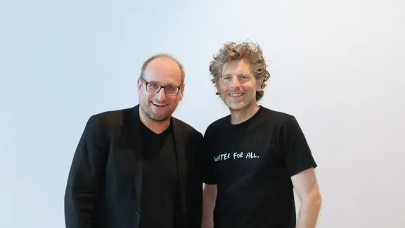Viva con Agua - Vorstand Arnd Boekhoff und Feel Hamburg - Host Daniel Kaiser stehen nebeneinander.