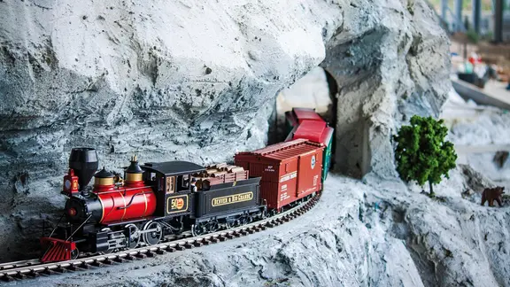 Eine Modelleisenbahn fährt durch eine Modellbauwelt.