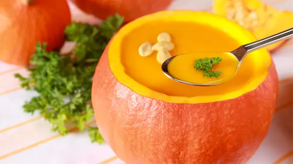 Kürbiscremesuppe im Kürbis angerichtet.