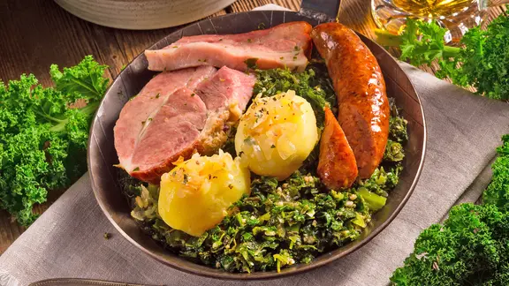 Beliebtes Gericht an kalten Tagen: Grünkohl mit Kohlwurst und Kasseler. | fotolia.com, Dar1930 Grünkohl mit Kassler, Pinkelwurst und Kartoffeln