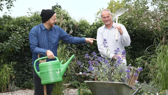 Samir Chawki und Thomas Balster stehen in einem Garten.
