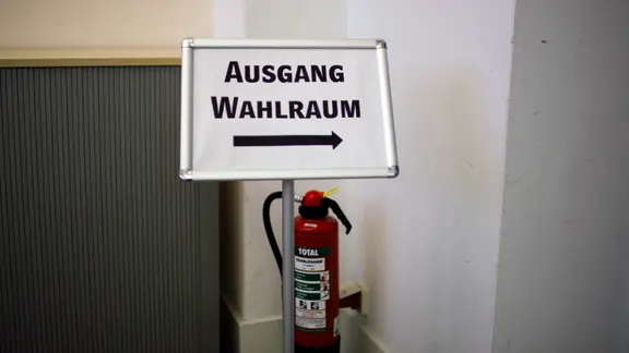 Ein Schild weist dem Weg zu Ausgang eines Wahlraums.