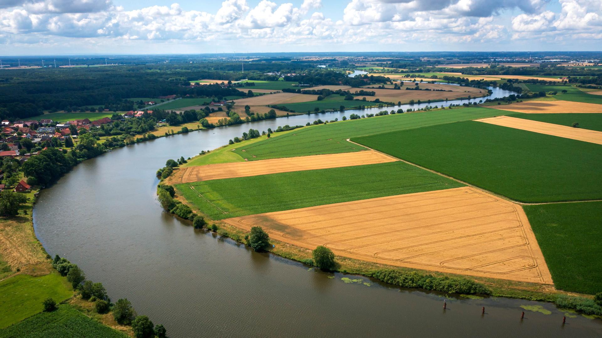 Der Fluss Weser fließt entlang von Feldern. | Sina Schuldt/dpa
