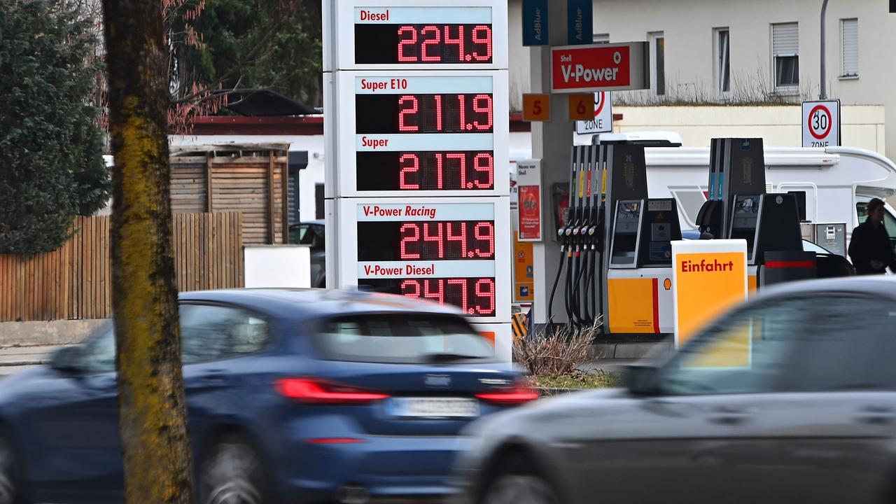 Autos fahren an der Anzeige einer Tankstelle vorbei