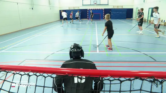 Eine Turnhalle, wo Kinder und Jugendliche Floorball spielen.