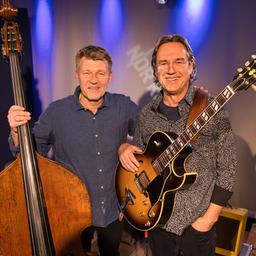 Ein Mann steht am Kontrabass und neben ihm steht ein anderer Mann und hält eine E-Gitarre.