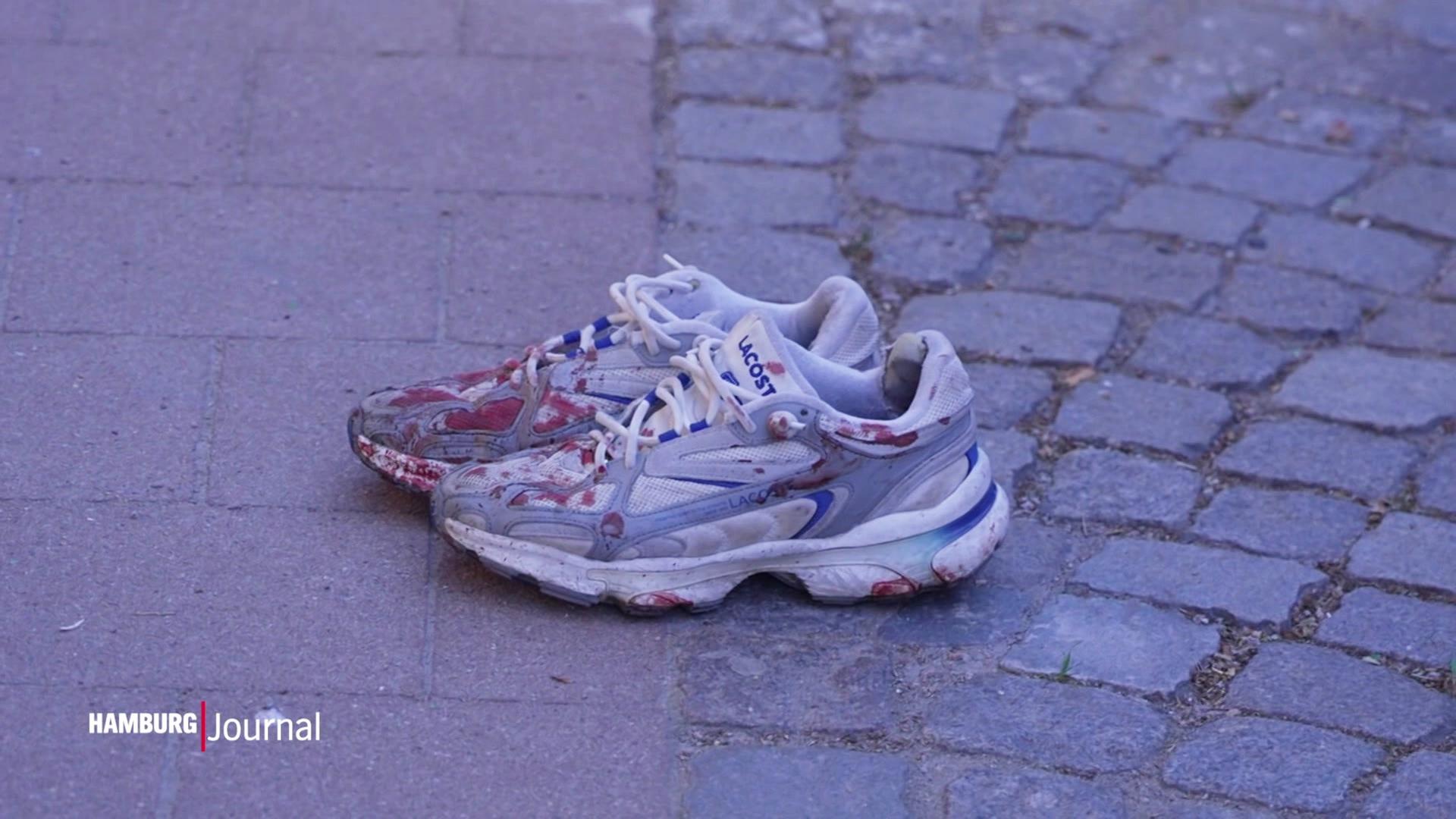 Ein blutiges Paar Turnschuhe auf der Straße. | Screenshot