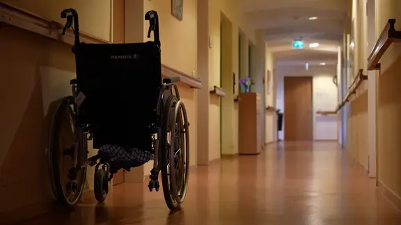 Rollstuhl steht in einem leeren Gang im Pflegeheim