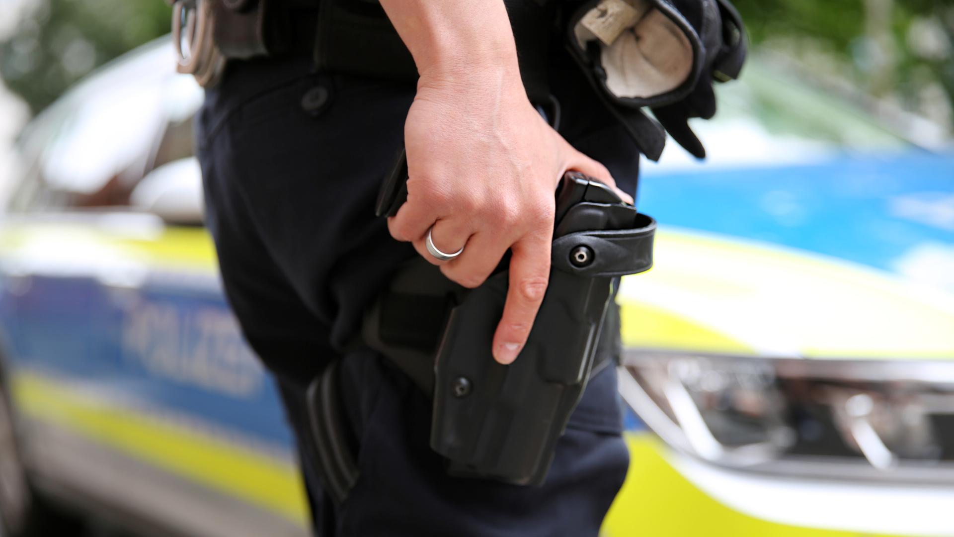 Ein Polizist hält seine Hand auf seiner geöffneter Dienstwaffe im Halfter am Gürtel. | NDR, Pavel Stoyan