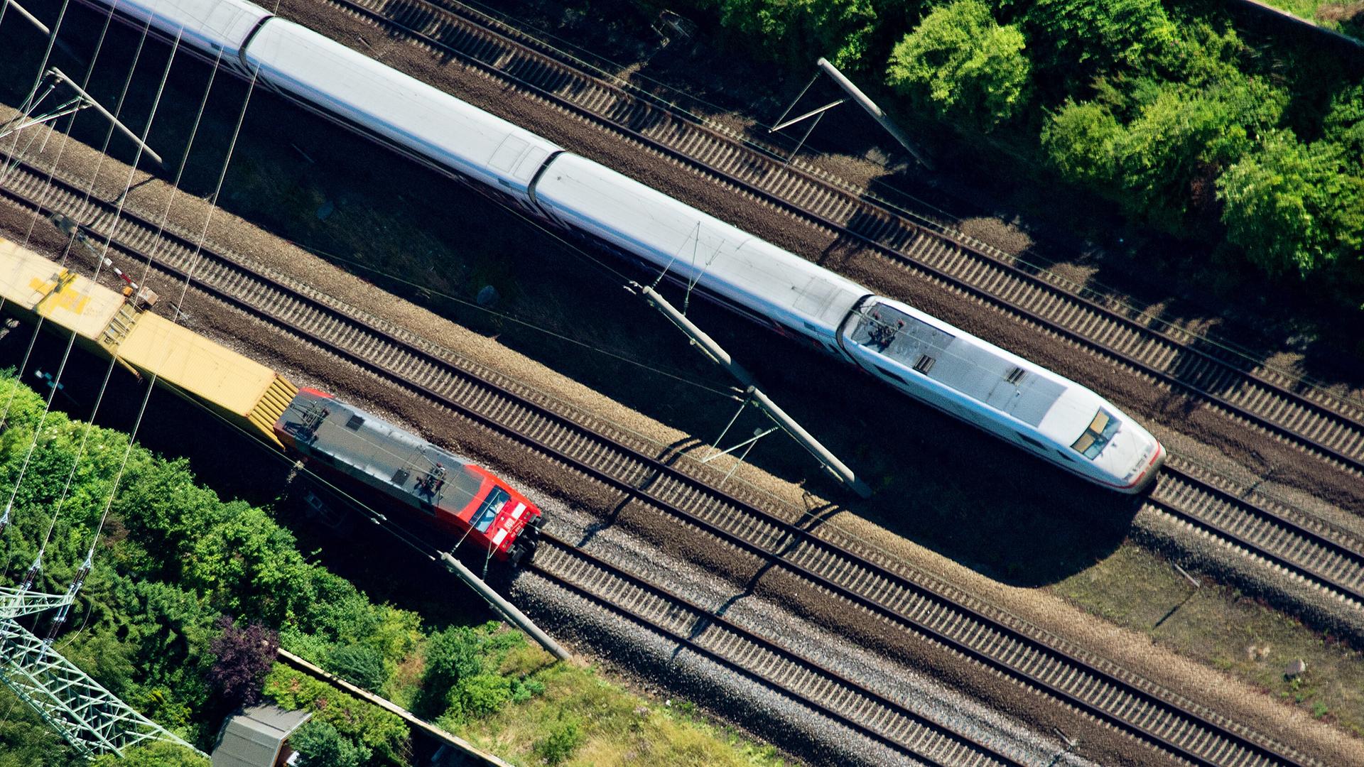 Ein ICE überholt einen Güterzug. | picture alliance / dpa | Julian Stratenschulte
