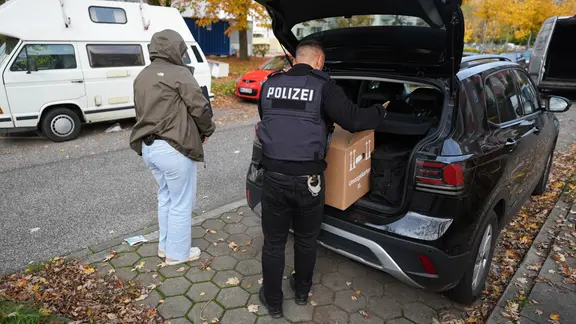 Polizisten tragen nach einer Razzia beschlagnahmtes Material aus einer Wohnung in Hamburg-Mümmelmannsberg. | dpa / Marcus Brandt Polizisten tragen nach einer Razzia beschlagnahmtes Material aus einer Wohnung in Hamburg-Mümmelmannsberg.