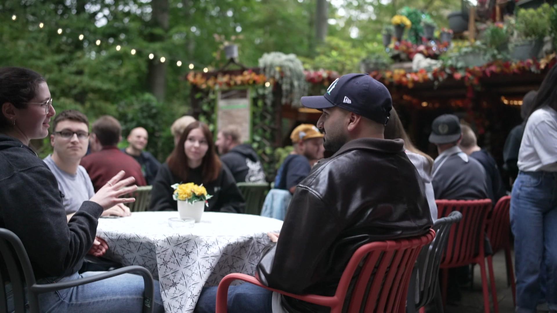 Kerem Ulug sitzt in einem Waldcafé. | NDR