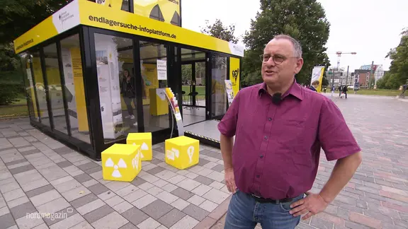 Eine Person vor einem Infomobil in Rostock.