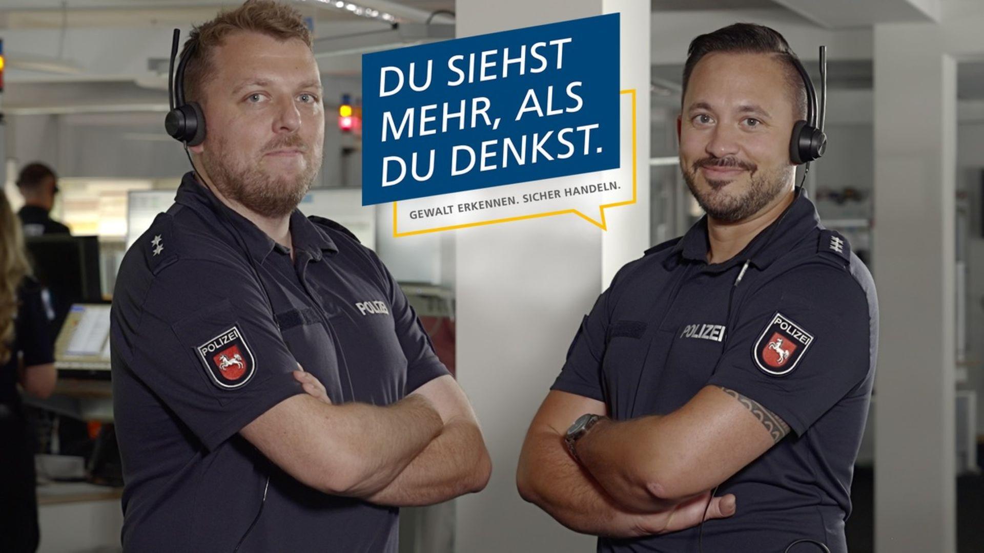 Zwei Polizisten schauen zwischen der Aufschrift 