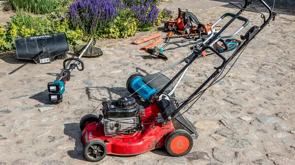 Nach der Reinigung sollten Rasenmäher frostfrei überwintern. | NDR, Udo Tanske Gartengeräte stehen auf einem gepflasterten Weg.