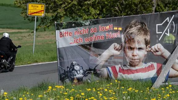 Ein Plakat bittet Motorradfahrer um Rücksicht.