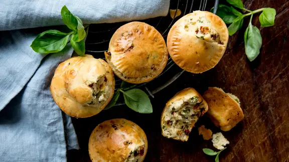 Pikante Muffins mit Basilikum und Stoffservietten auf einem Holztisch | NDR, Claudia Timmann Pikante Muffins mit Basilikum und Stoffservietten auf einem Holztisch