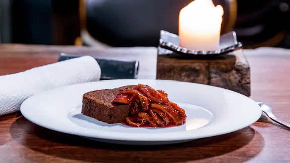 Eine Stück Schokoladenkuchen mit eingemachten Zwetschgen auf einem weißen Teller angerichtet | NDR/Claudia Timmann Eine Stück Schokoladenkuchen mit eingemachten Zwetschgen auf einem weißen Teller angerichtet