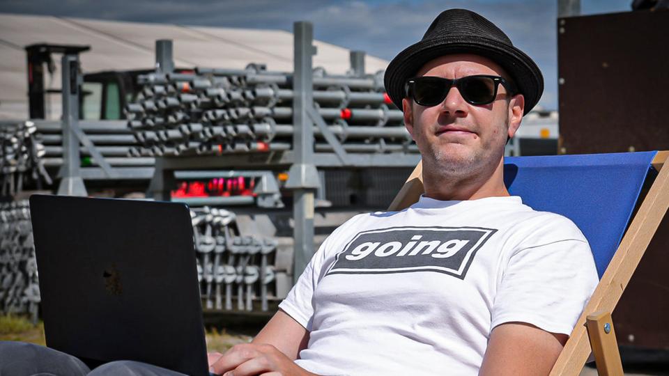 Matthes Köppinghoff sitzt in einem Strandstuhl mit einem Laptop auf dem Schoß