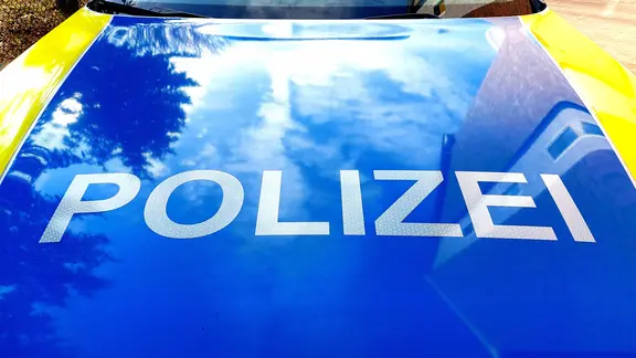 Die Motorhaube eines Polizeiautos mit Schriftzug.
