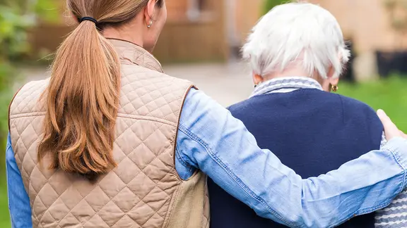 Eine junge Frau umarmt eine ältere Frau.