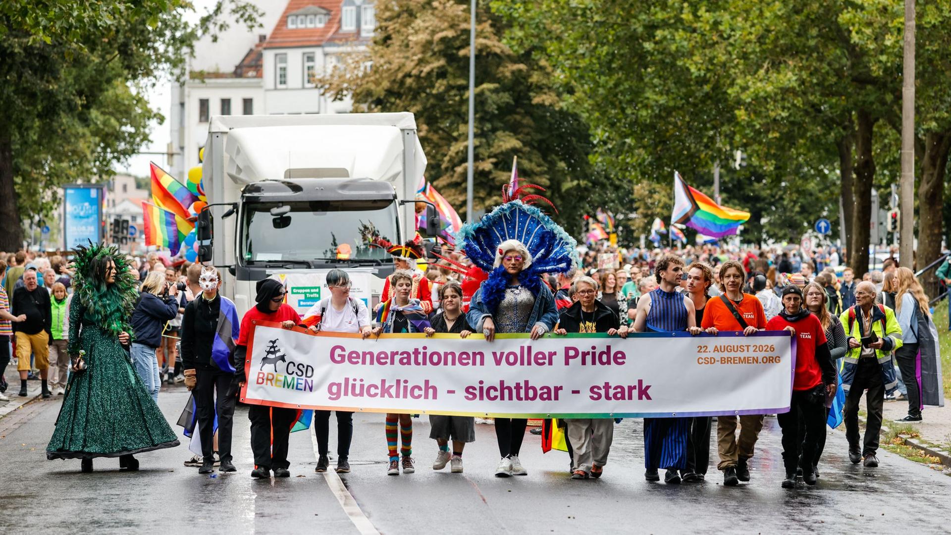 CSD-Teilnehmer gehen in Bremen hinter einen Transparent: 