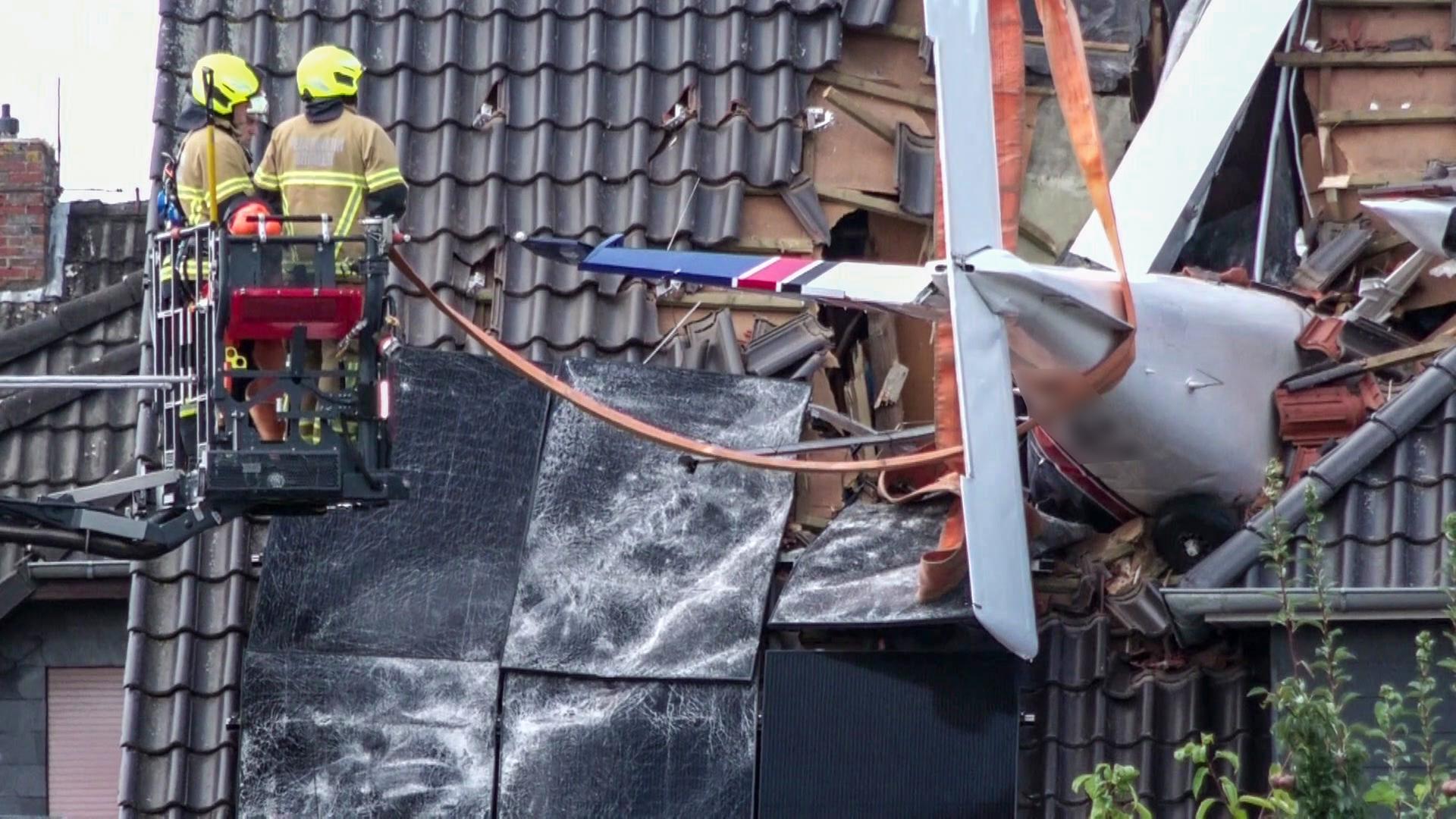 Feuerwehrleute bei der Bergung eines Kleinflugzeuges, das mit dem Dachstuhl eines Wohnhauses in Ganderkesee kollidiert ist | NonstopNews