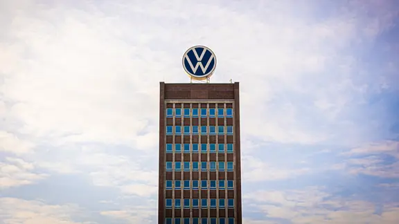 Das Volkswagen-Logo steht auf dem Dach vom Markenhochhaus in Wolfsburg.