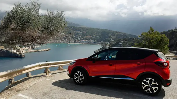 Ein Mietwagen steht auf dem Parkplatz am Leuchtturm Far del Cap Gros mit der grandiosen Aussicht auf die Hafenbucht von Port de Soller auf Mallorca.