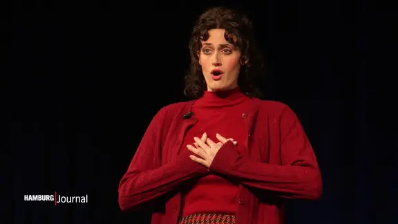 Eine Sängerin auf einer Theaterbühne.