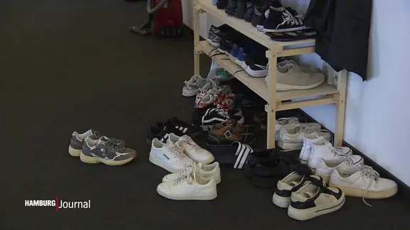 Ein volles Schuhregal im Flur einer WG.