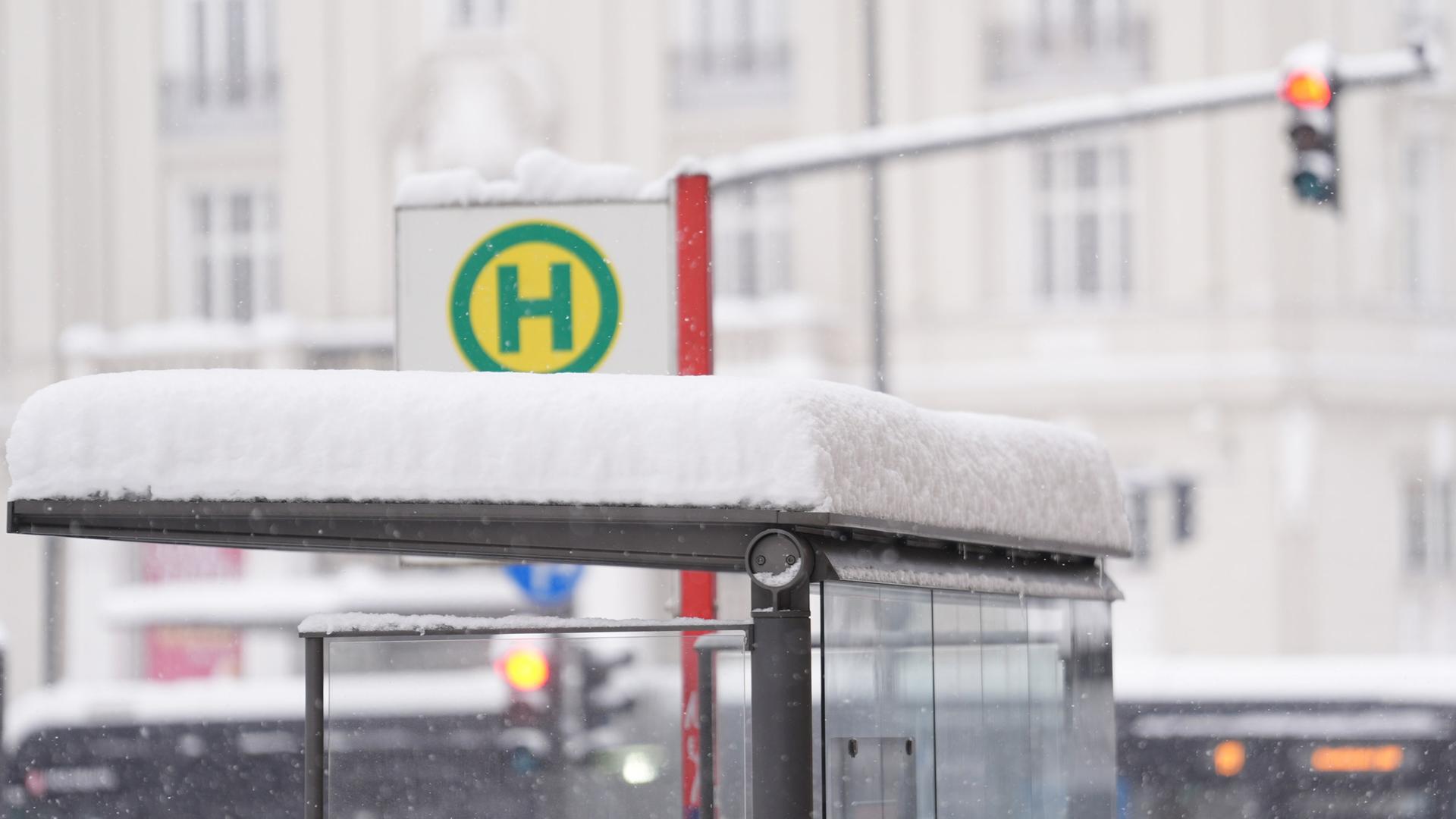Eine mehrere Zentimeter dicke Schneeschicht liegt auf dem Dach eines Bushaltestellenhäuschens | picture alliance / dpa, Marcus Brandt