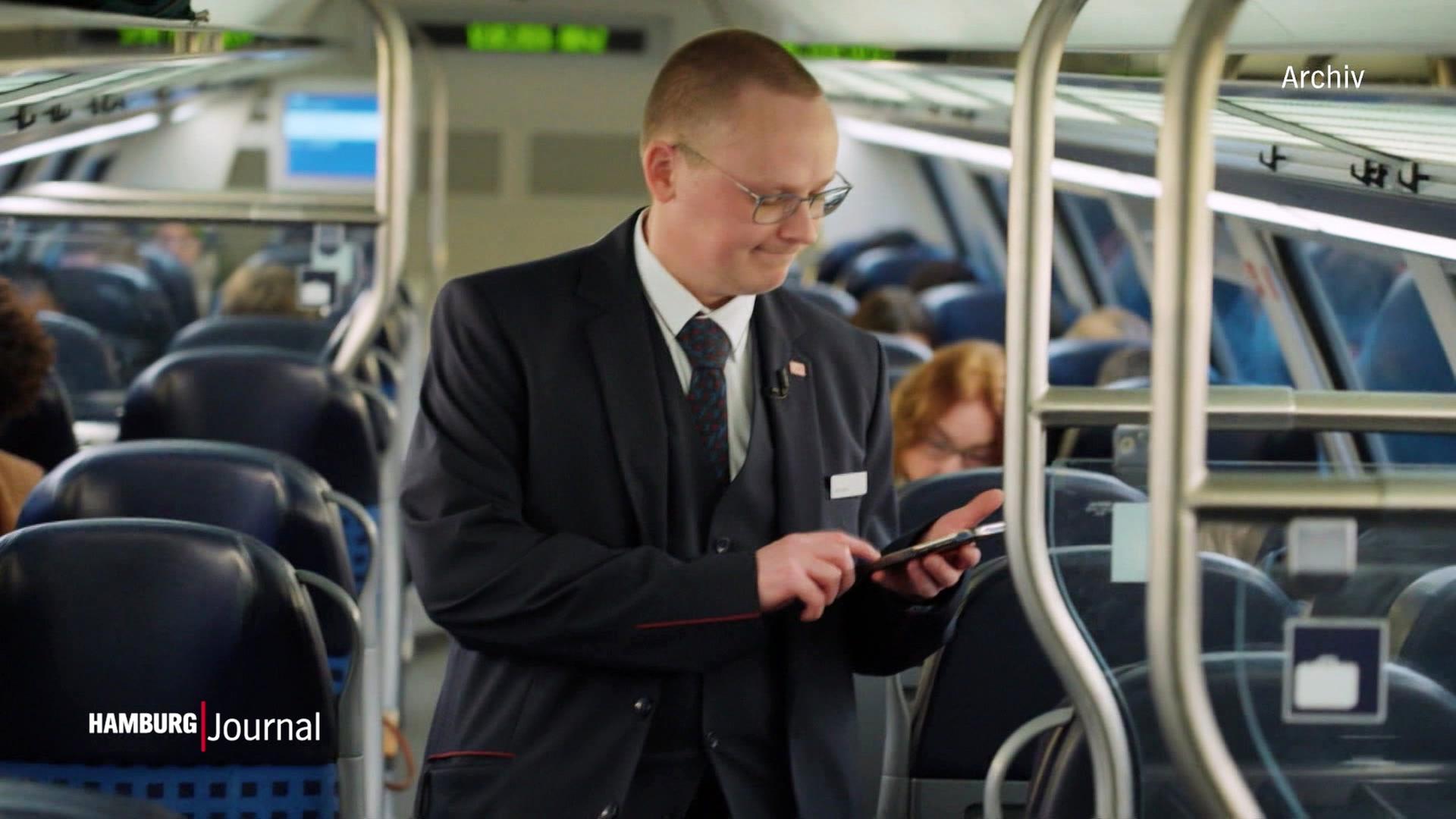 Ein Zugbegleiter kontrolliert die Tickets der Fahrgäste (Archivbild). | Screenshot