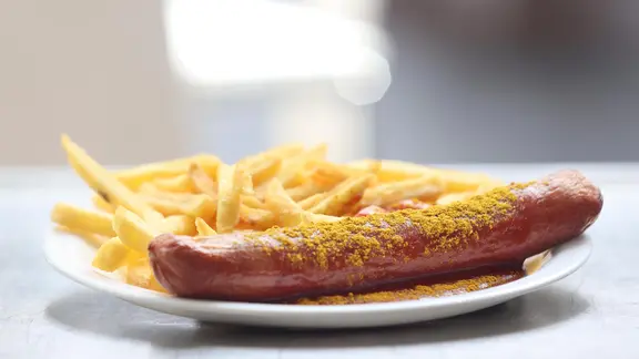 Eine Currywurst mit Pommes in einer Volkswagenkantine.
