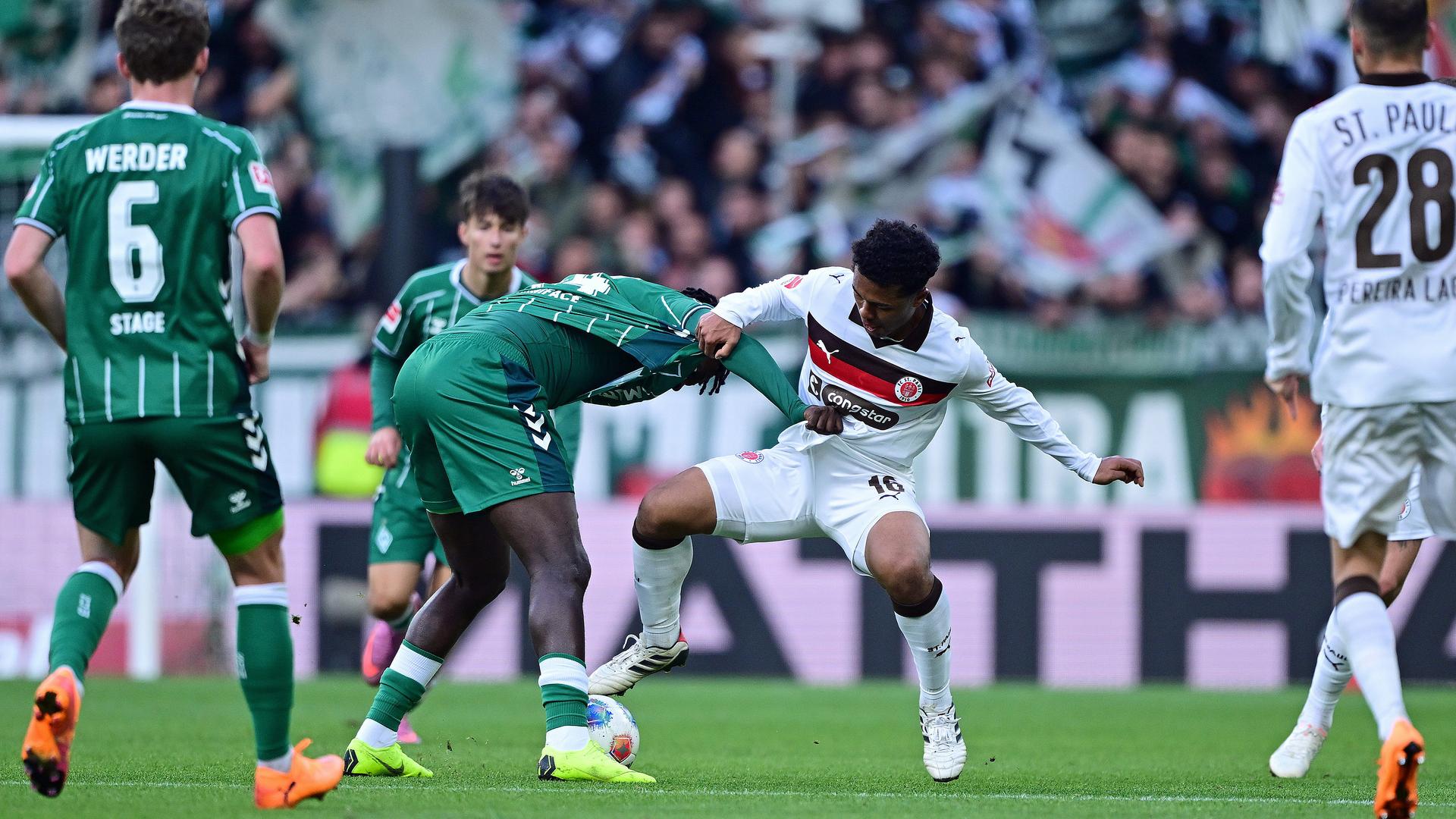 Werder Bremens Victor Boniface (2.vl.) im Zweikampf mit St. Paulis Joel Chima Fujita (3.v.l.). | Witters / Leonie Horky