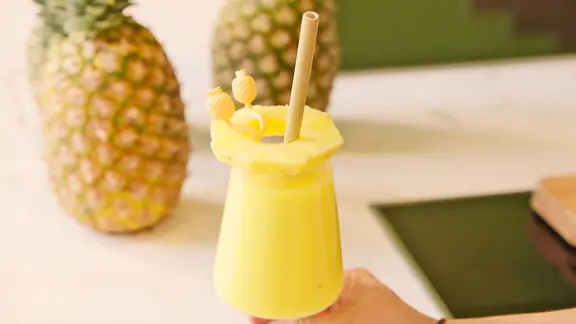 Ein mit einer Ananas-Scheibe dekorierter Smoothie, im HIntergrund zwei Ananas-Früchte. | BR Screenshot Ein mit einer Ananas-Scheibe dekorierter Smoothie, im HIntergrund zwei Ananas-Früchte.