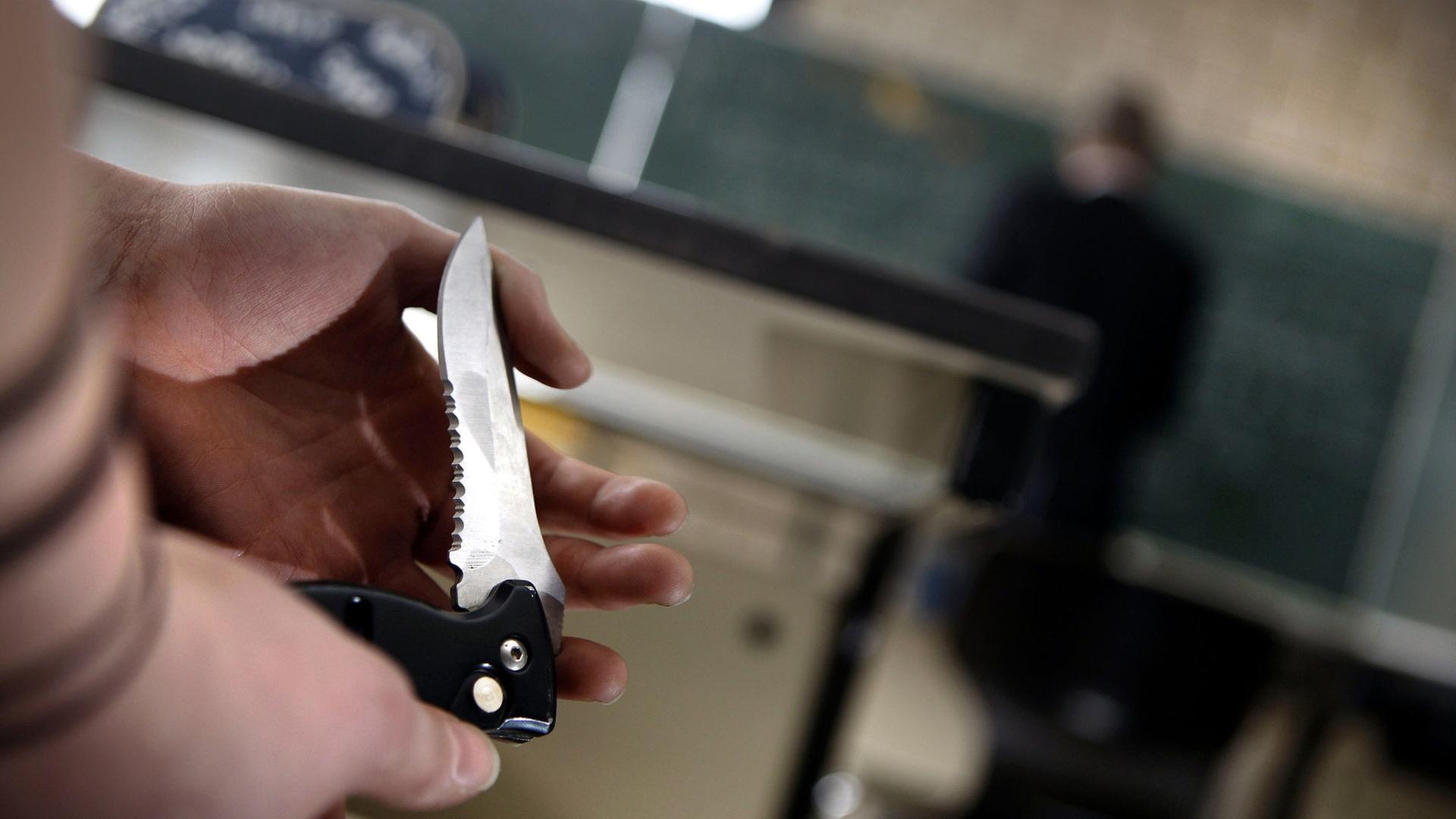 Eine Schülerin zeigt während des Unterrichts einer Mitschülerin ihr Klappmesser. | picture alliance / dpa , Oliver Berg