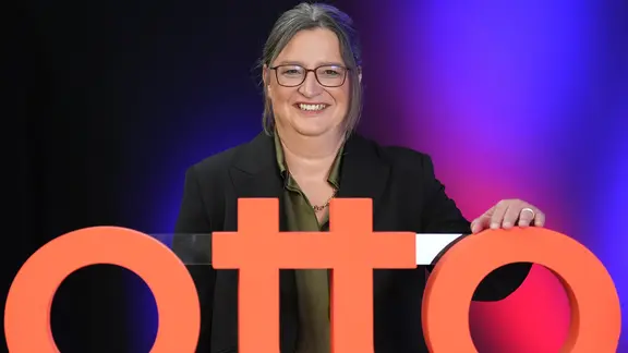 Petra Scharner-Wolff, Vorstandsvorsitzende der Otto Group, steht hinter einem "Otto"-Schriftzug.