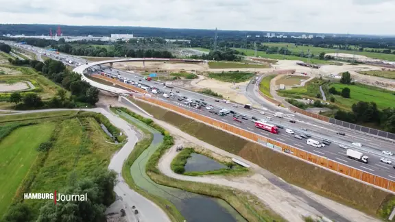 Eine Autobahn mit Autos und LKWs, gefilmt von oben.