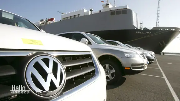 Mehrere Fahrzeuge der Marke VW stehen vor einer Autofähre.